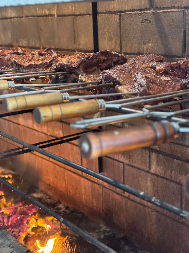 Costelas em espetos de cabo de madeira sobre o fogo