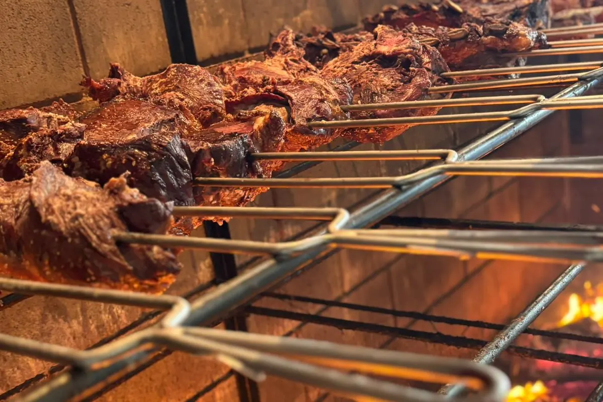 Costelas assando em espetos sobre a brasa do fogo de chão